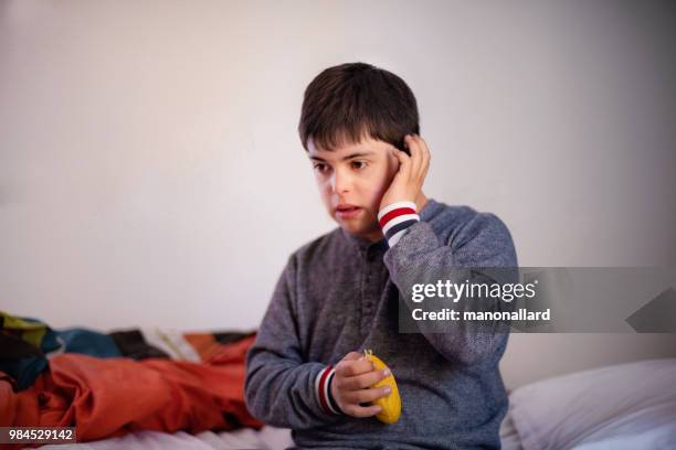 portrait of an authentic boy of 12 years old with autism and down syndrome in daily lives - old trying to look young stock pictures, royalty-free photos & images