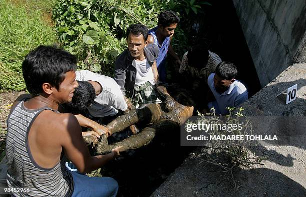 Relatives carry the body of a man who was killed by suspected separatists in Thailand's restive southern Narathiwat province on April 14, 2010. The...