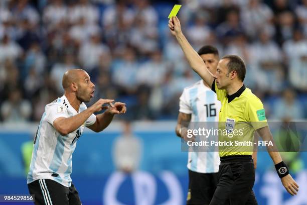 Referee Cuneyt Cakir gives a yellow card to Javier Mascherano of Argentina after awarding a penalty aganist him during the 2018 FIFA World Cup Russia...