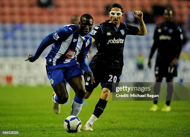 Mohamed Diame of Wigan is challenged by Tommy Smith of Portsmouth during the Barclays Premier League match between Wigan Athletic and Portsmouth at...