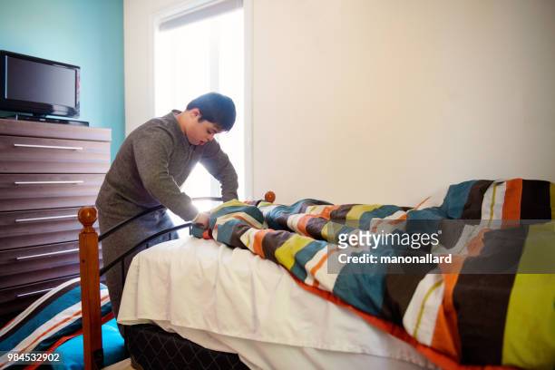 Autentiska pojke 12 år med Autism och Downs syndrom i dagliga liv att göra säng