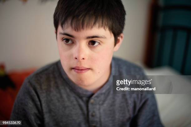 Porträtt av en autentisk pojke 12 år med Autism och Downs syndrom i vardagen