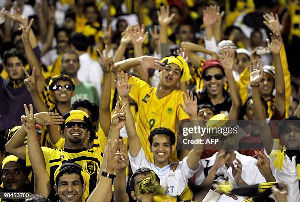 Saudi Al-Ittihad's fans cheer for their team before their AFC Champions League group B football match against Uzbekistan's Bunyodkor in Jeddah on...