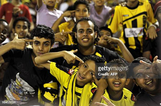 Saudi Al-Ittihad's fans cheer for their team before their AFC Champions League group B football match against Uzbekistan's Bunyodkor in Jeddah on...