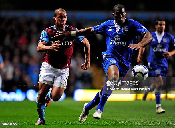 Gabriel Agbonlahor of Aston Villa is held off by Sylvain Distin of Everton during the Barclays Premier League match between Aston Villa and Everton...