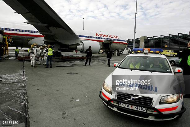 Emergency servises personnel gather beside an American Airlines plain following its emergency landing at the airport in Keflavik on April 13, 2010....