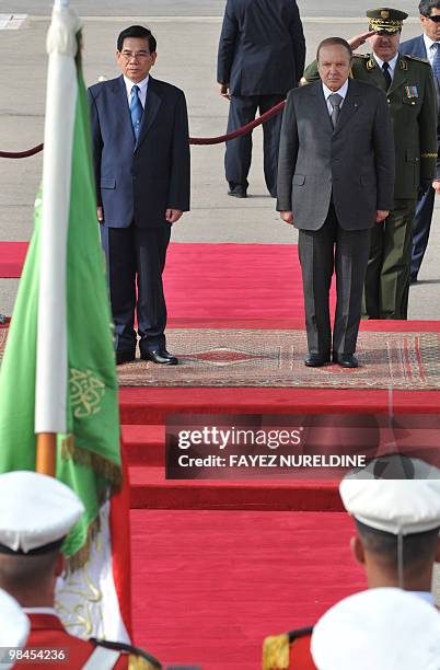 Algerian President Abdelaziz Bouteflika walks with his Vietnamese counterpart Nguyen Minh Triet listen to the national anthems during a welcoming...