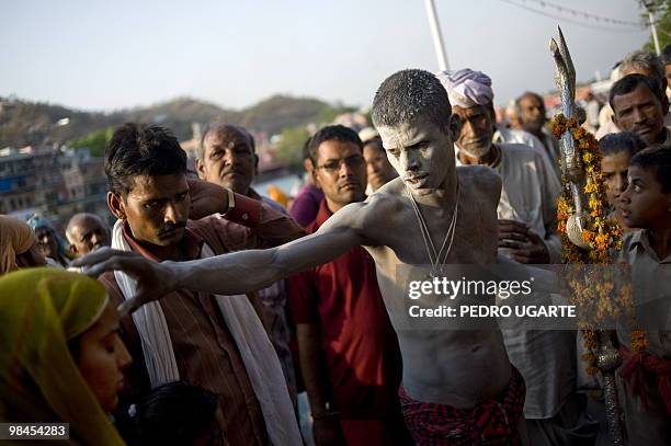 Hindu holi man puts a tikka on the forehead of a woman on the banks of river Ganges during the Kumbh Mela festival in Haridwar on April 13, 2010. The...