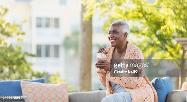 高級非裔美國婦女在天井放鬆 - coffee on patio 個照片及圖片檔