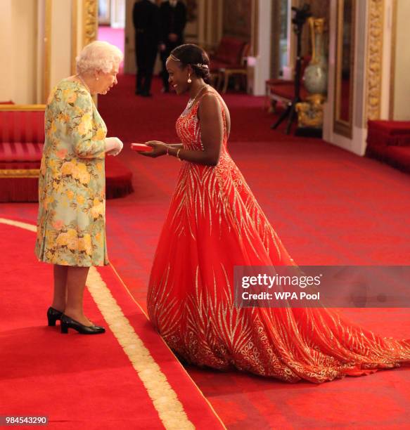 Ms Elizabeth Kasujja from Uganda receives her Young Leaders Award from Queen Elizabeth II during the Queen's Young Leaders Awards Ceremony at...