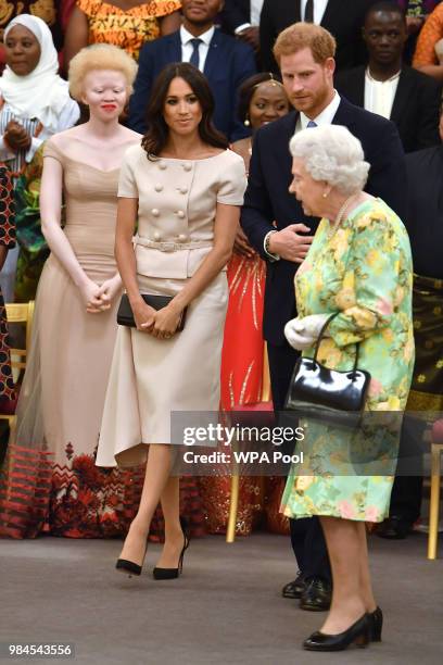 Meghan, Duchess of Sussex with Queen Elizabeth II and Prince Harry, Duke of Sussex at the Queen's Young Leaders Awards Ceremony at Buckingham Palace...
