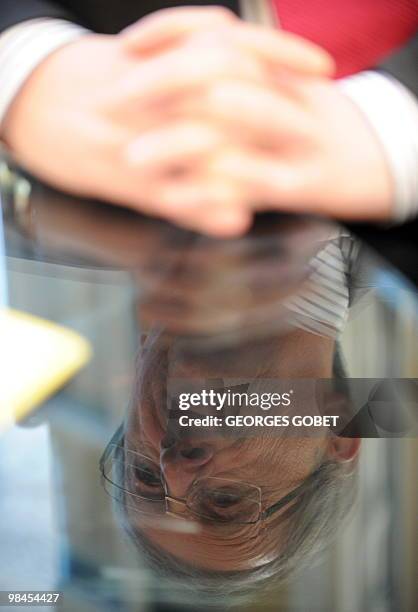 Eurogroup president and Luxembourg Prime Minister Jean-Claude Juncker is reflected on a table as he listens to questions in his personal office on...