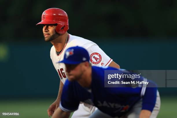 Albert Pujols of the Los Angeles Angels of Anaheim leads off first base as Justin Smoak of the Toronto Blue Jays defends during a game at Angel...