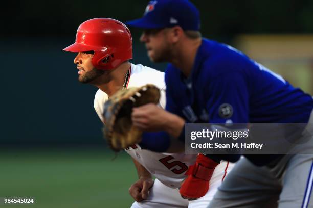 Albert Pujols of the Los Angeles Angels of Anaheim leads off first base as Justin Smoak of the Toronto Blue Jays defends during a game at Angel...