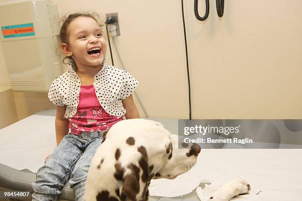 Arwen Delgado plays with Lacie the show dog during a visit to hospitalized children at Beth Israel Medical Center on April 14, 2010 in New York City.