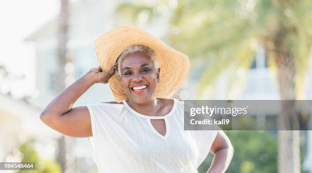 senior african-american woman on tropical vacation - wide brim stock pictures, royalty-free photos & images