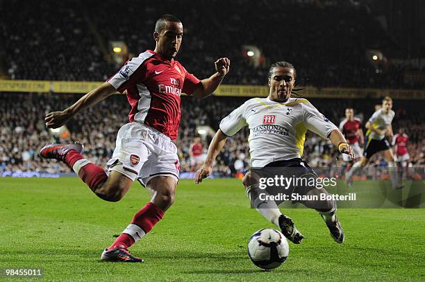 Theo Walcott of Arsenal is challenged by Benoit Assou-Ekotto of Tottenham Hotspur during the Barclays Premier League match between Tottenham Hotspur...