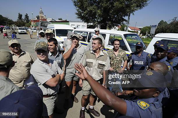 Supporters of the white sepremacist Afrikaner Resistance Movement face police on April 14, 2010 outside the Ventersdorp courthouse. The court on...