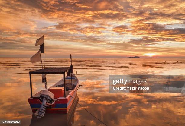 a boat at sunset in permatang damar laut, penang, malaysia. - laut stock pictures, royalty-free photos & images