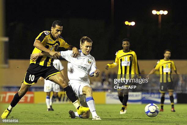 Bunyodkor's Ruslan Melziddinov is challenged by Al-Ittihad's Algerian striker Abdelmalek Ziaya during their AFC Champions League group B football...