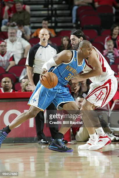 David West of the New Orleans Hornets drives the ball past Luis Scola of the Houston Rockets on April 14, 2010 at the Toyota Center in Houston,...