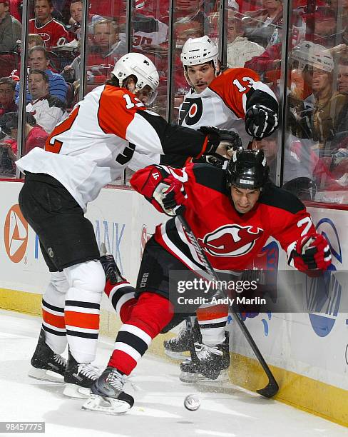 Mike Mottau of the New Jersey Devils is checked hard into the boards by Simon Gagne of the Philadelphia Flyers in Game One of the Eastern Conference...