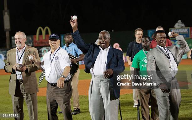 Baseball Hall of Famers Bruce Sutter, Bob Feller, Hank Aaron and Rickey Henderson throw out the first pitch during pre-game ceremonies following the...