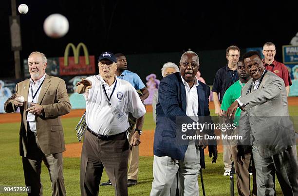 Baseball Hall of Famers Bruce Sutter, Bob Feller, Hank Aaron and Rickey Henderson throw out the first pitch during pre-game ceremonies following the...