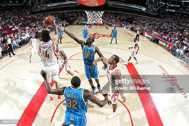 Emeka Okafor of the New Orleans Hornets shoots the ball over Luis Scola of the Houston Rockets on April 14, 2010 at the Toyota Center in Houston,...