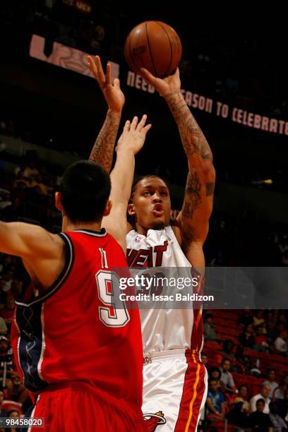 Michael Beasley of the Miami Heat shoots against Yi Jianlian of the New Jersey Nets on April 14, 2010 at American Airlines Arena in Miami, Florida....