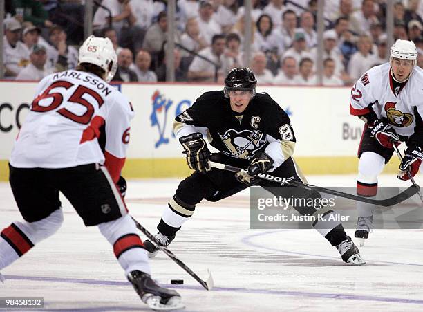 Sidney Crosby of the Pittsburgh Penguins pursues the puck in front of Erik Karlsson of the Ottawa Senators in Game One of the Eastern Conference...