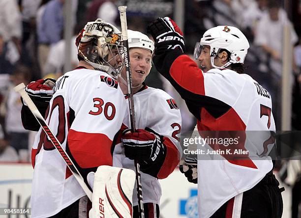 Chris Neil and Matt Cullen celebrate with Brian Elliott of the Ottawa Senators after winning Game One of the Eastern Conference Quarterfinals during...