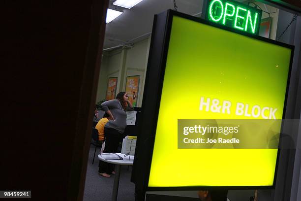 Amanda Valles, a H&R Block Tax Associate, takes a break from helping customers with their taxes the night before the Internal Revenue Service...