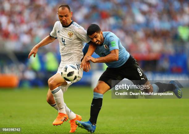 Luis Suarez of Uruguay battles for the ball with Sergey Ignashevich of Russia during the 2018 FIFA World Cup Russia group A match between Uruguay and...