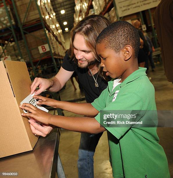 Former American Idol's Bo Bice and Volunteer participate in the "Idol Gives Back" Volunteer Program at the Second Harvest Food Bank of Middle...