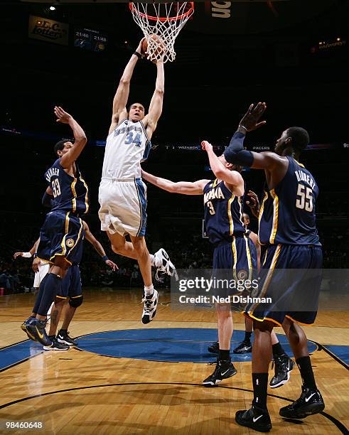 JaVale McGee of the Washington Wizards shoots against Danny Granger and Troy Murphy of the Indiana Pacers at the Verizon Center on April 14, 2010 in...