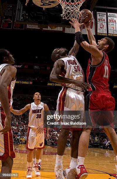 Joel Anthony of the Miami Heat blocks against Brook Lopez of the New Jersey Nets on April 14, 2010 at American Airlines Arena in Miami, Florida. NOTE...