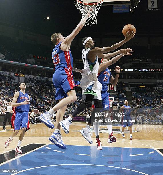 Corey Brewer of the Minnesota Timberwolves goes up for a layup against Charlie Villanueva and Jonas Jerebko of the Detroit Pistons during the game on...