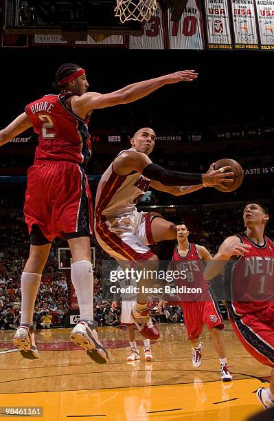 Carlos Arroyo of the Miami Heat shoots against Josh Boone of the New Jersey Nets on April 14, 2010 at American Airlines Arena in Miami, Florida. NOTE...