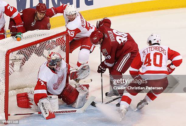 Vernon Fiddler of the Phoenix Coyotes attempts a shot on goaltender Jimmy Howard of the Detroit Red Wings as Henrik Zetterberg and Niklas Kronwall...