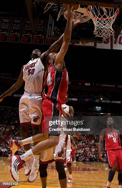 Joel Anthony of the Miami Heat blocks against Devin Harris of the New Jersey Nets on April 14, 2010 at American Airlines Arena in Miami, Florida....