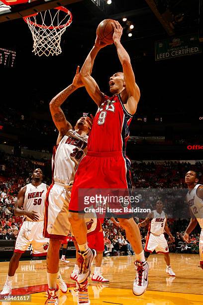 Yi Jianlian of the New Jersey Nets grabs a rebound against Michael Beasley of the Miami Heat ton April 14, 2010 at American Airlines Arena in Miami,...