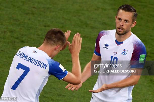 Iceland's midfielder Gylfi Sigurdsson celebrates with Iceland's midfielder Johann Gudmundsson after scoring a goal during the Russia 2018 World Cup...