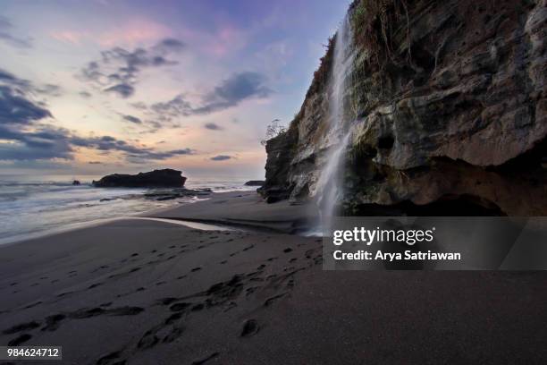 mini waterfall at melasti beach - melasti fotografías e imágenes de stock