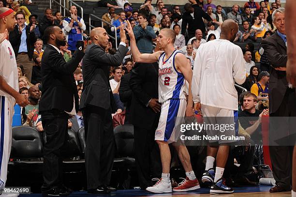 Steve Blake of the Los Angeles Clippers is congratulated by Assistant Coach Fred Vinson and teammate Baron Davis following their team's victory over...