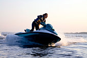 Woman on a jet ski in the ocean during the sunset