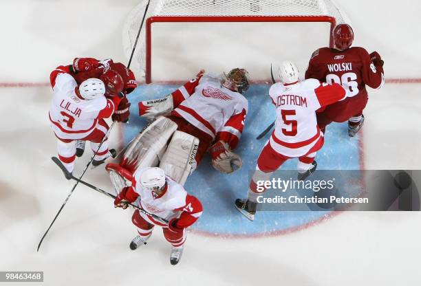 Goaltender Jimmy Howard of the Detroit Red Wings lays on the puck in the crease after making a save against the Phoenix Coyotes in Game One of the...