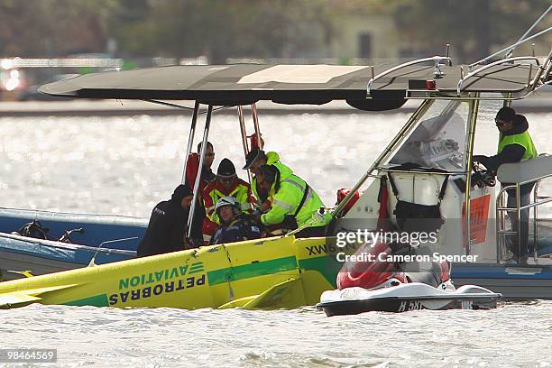 Adilson Kindlemann of Brazil crashes into the Swan River as Emergency Services rush to his aid during the Red Bull Air Race Training day on April 15,...