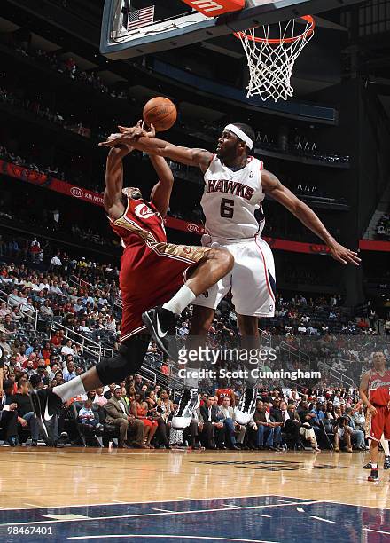 Mario West of the Atlanta Hawks defends a drive to the basket by Leon Powe of the Cleveland Cavaliers on April 14, 2010 at Philips Arena in Atlanta,...