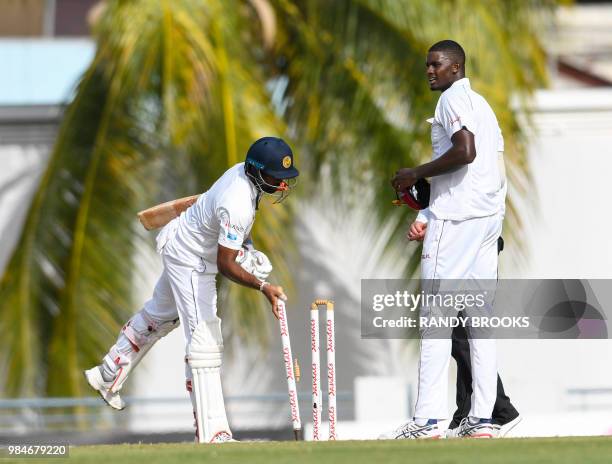 Dilruwan Perera of Sri Lanka takes the stumps as Jason Holder of West Indies look on at the end of day 4 of the 3rd Test between West Indies and Sri...